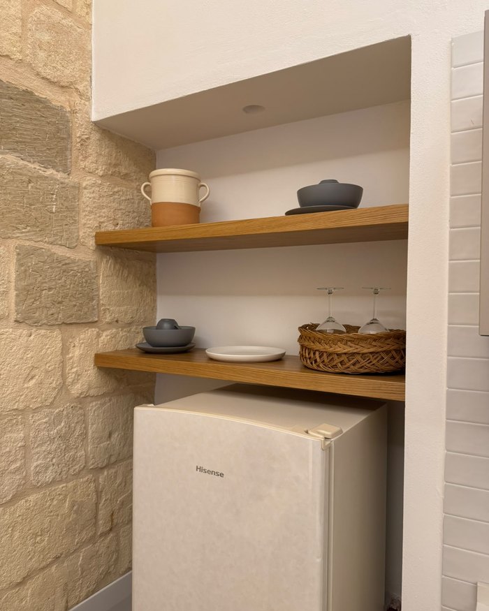 Le mensole in legno con le stoviglie, nell'appartamento La Rimesa