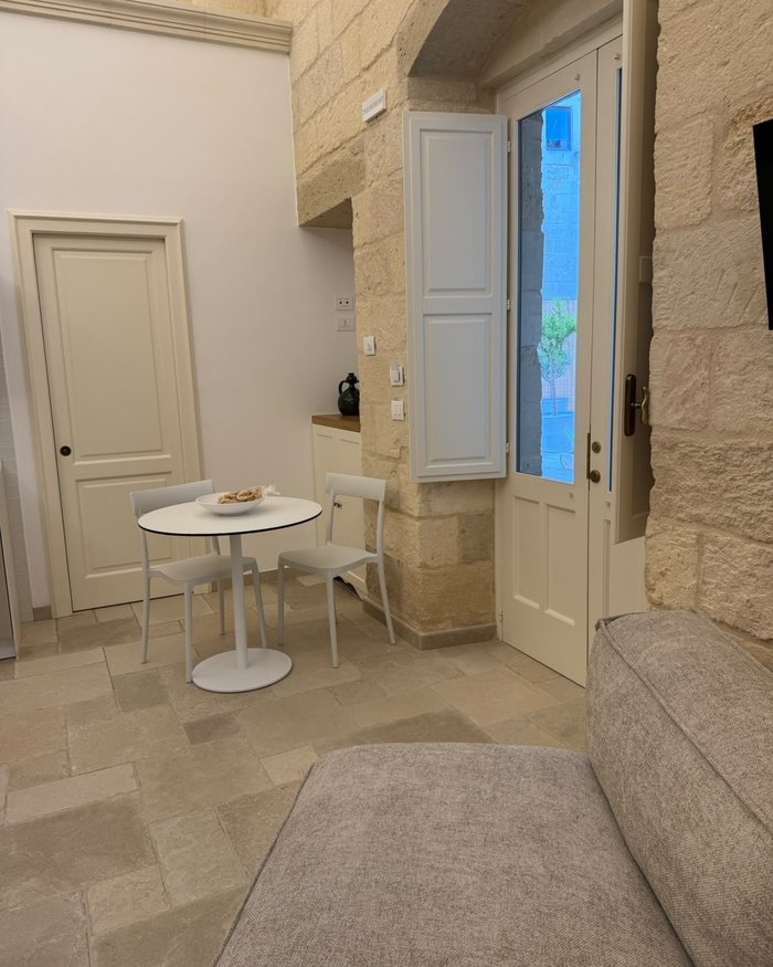 Il tavolo da pranzo dell'appartamento La Rimesa, accanto alla porta a vetri sulla corte