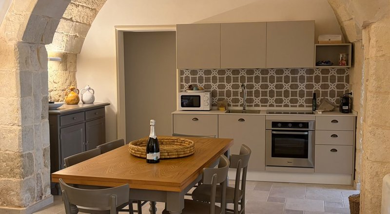 La cucina con l'arco in pietra dell'appartamento Zia Nena