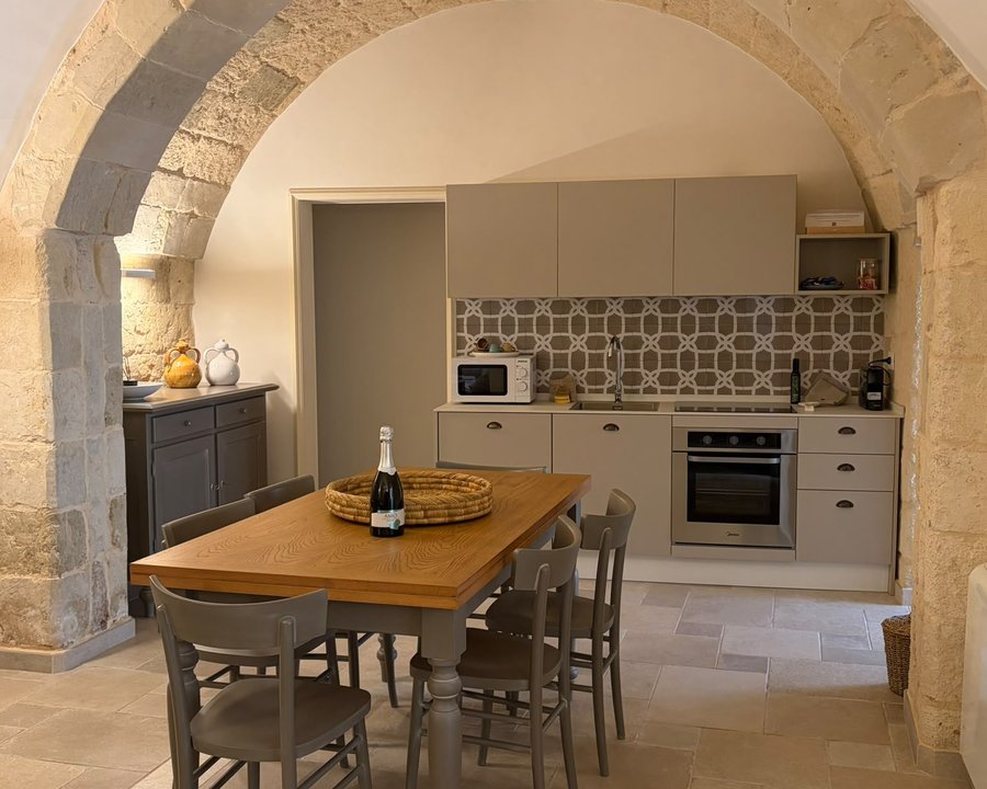 La cucina con l'arco in pietra dell'appartamento Zia Nena